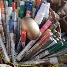 Pletena korpica puna Uni-ball Paint markera različitih boja i debljina.
